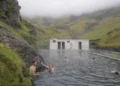 People bathing in an outdoor pool in Icelandic landscape