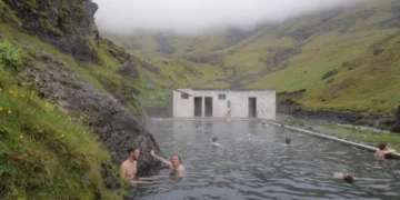 People bathing in an outdoor pool in Icelandic landscape
