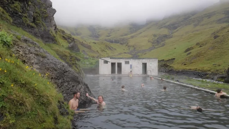 People bathing in an outdoor pool in Icelandic landscape