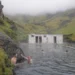 People bathing in an outdoor pool in Icelandic landscape