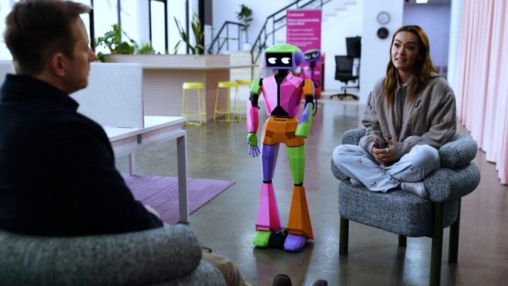 An interview beside a colourful humanoid robot in the News24 documentary Artificial Intelligence: Who’s in Control?