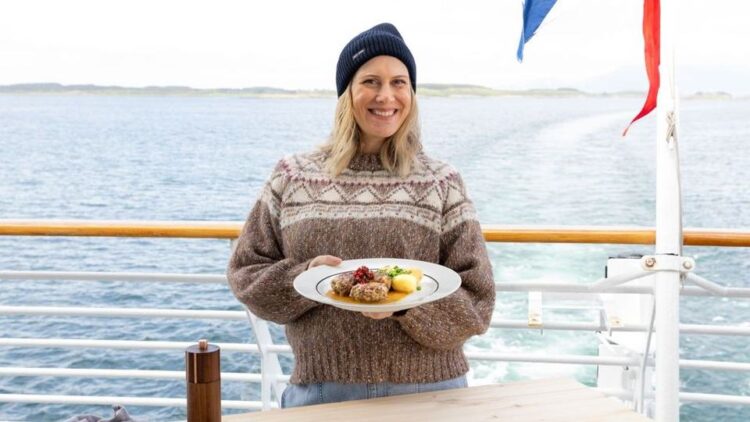 Justine Schofield holds a Norwegian dish aboard a Hurtigruten ship in Norway Gourmet