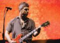 Noel Gallagher playing guitar during the Oasis reunion tour