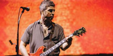 Noel Gallagher playing guitar during the Oasis reunion tour