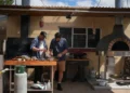 Colin Fassnidge and Manu Feildel prepare food at an outdoor kitchen