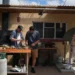 Colin Fassnidge and Manu Feildel prepare food at an outdoor kitchen