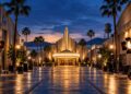 Illuminated film studio lot at dusk, representing the Paramount and Warner Bros. Discovery merger