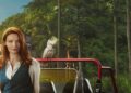 Anna Samson as Mackenzie Clarke beside a red vehicle and cockatoo in Return to Paradise season three