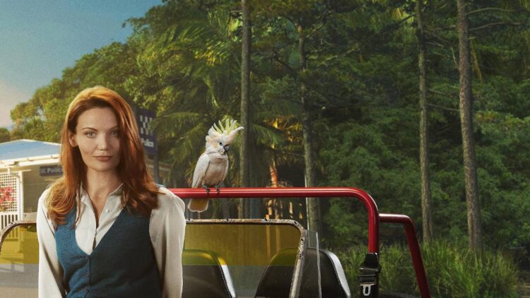 Anna Samson as Mackenzie Clarke beside a red vehicle and cockatoo in Return to Paradise season three