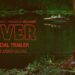A figure stands at the water’s edge in the River trailer key art