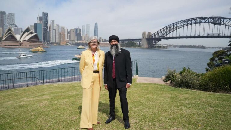 Governor-General Sam Mostyn and Sukhdeep Singh Bhogal standing beside Sydney Harbour