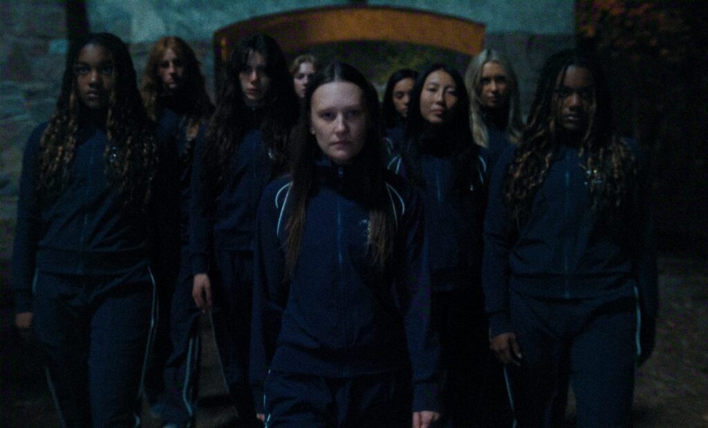 A group of schoolgirls in navy uniforms walk together at night in The Body on Netflix