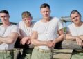 Four Marine recruits in white t-shirts and dog tags at a training course in The Mosquito Bowl on Netflix